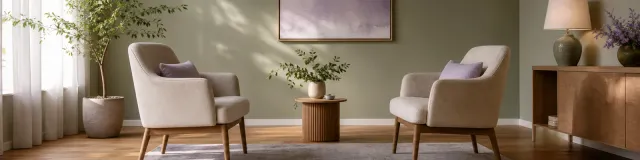 A minimalist calming therapy room with two facing chairs and soft directional light on a wooden floor