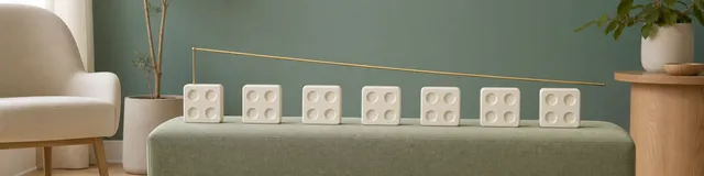 Seven cream assessment tiles with four response indents each beside a descending brass line representing score trends