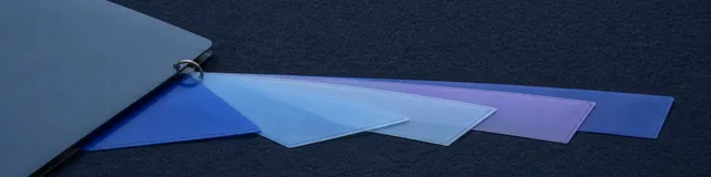 Five translucent blue document sleeves fan from one gray ring binder across dark charcoal fabric