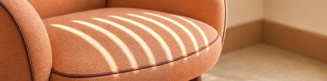 Bright window-light bands across an empty apricot therapy chair, suggesting repeated depression check-ins over time