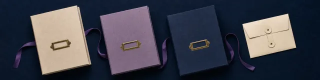 Cream, lavender, and navy archival record cases with blank brass date-tab holders linked by a purple archive ribbon